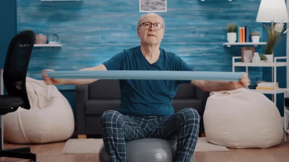 Pensioner on Toning Ball Training with Resistance Band alt