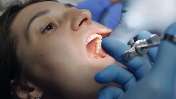 A Dentist Applies an Injection of Anesthetic Before Removing a Tooth to a Patient in a Dental Clinic