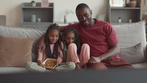 Dad Watching TV with Daughters Laughing alt