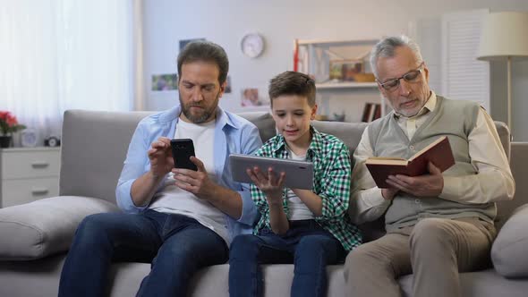 Middle-Aged Male and Preteen Boy Scrolling Gadgets, Aging Man Reading Paper Book alt