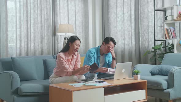 Asian Couple Looking At The Bill And Checking Money On The Purse Then Having Headache alt