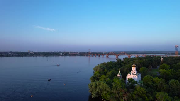 Arch bridge and Monastyrsky Island in the rays of the sunset, Dnipro, Ukraine.