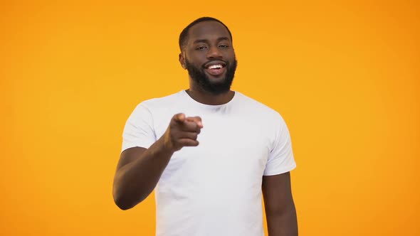 African American Man Pointing Finger at Camera and Winking, Smiling Knowingly alt