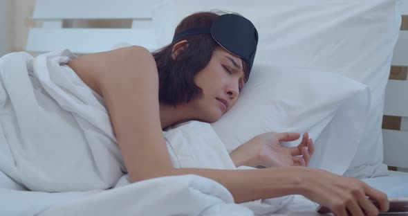 Asian young woman wake up when smartphone calling