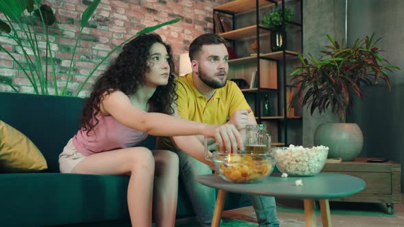 At Home in Living Room Attractive Couple Watching alt