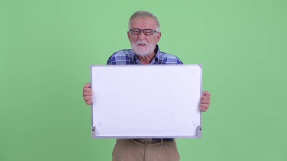 Happy Senior Bearded Hipster Man Talking While Holding White Board alt