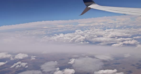 Flying Traveling View From Airplane Window on the Wing on Clouds Blue Sky alt