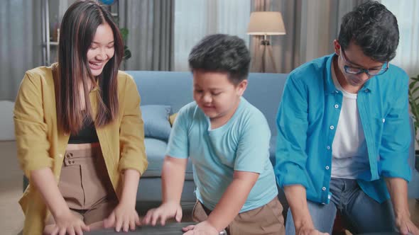 Happy Asian Family Helping Close Suitcase And Relax For A New Journey. Luggage For Travel Holidays alt