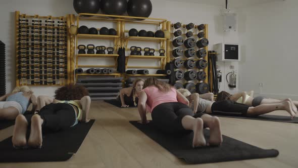 Group of adult women doing yoga exercises in gym