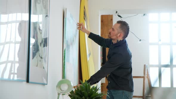 Creative Couple Hangs Painting in Modern Apartment