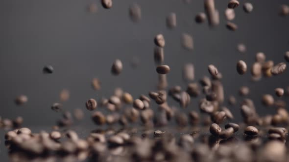 Brown Coffee Grains Falling on Surface Bouncing Closeup alt