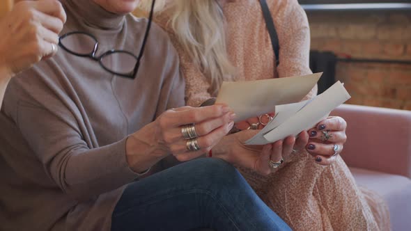 Three Senior Women Talking while Looking at Old Photos alt