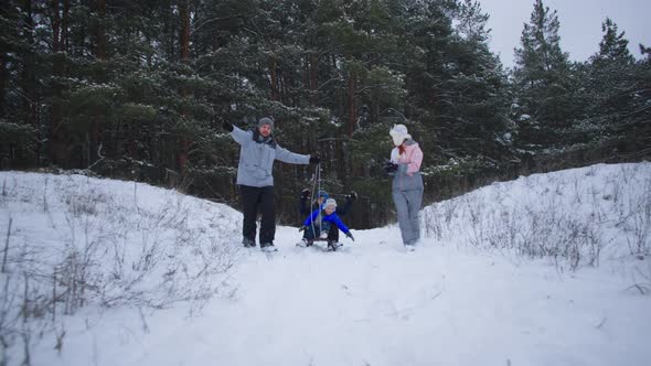 Outdoor Activities Cheerful Parents with Little Cute Boys Have Fun Outside the City Sledding and