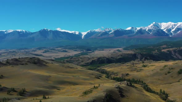 fields and mountains with snow capped peaks