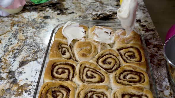 Icing homemade cinnamon rolls with cream cheese frosting alt