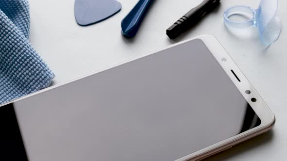 maintenance and repairing smartphones. spin on table many tempered glass screen protectors and mobil alt