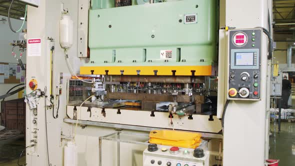 A large industrial punch press forming high precision metal parts for the automotive industry alt