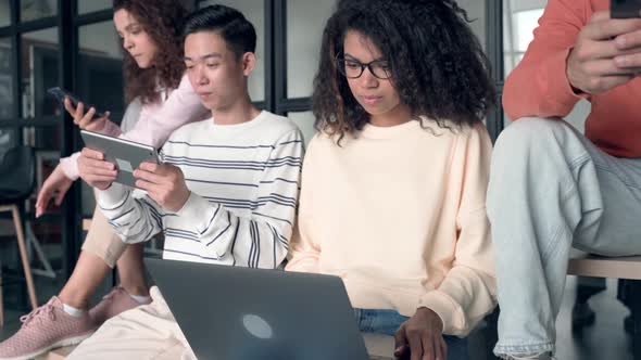 Multicultural Students at High School Campus Using Gadgets alt