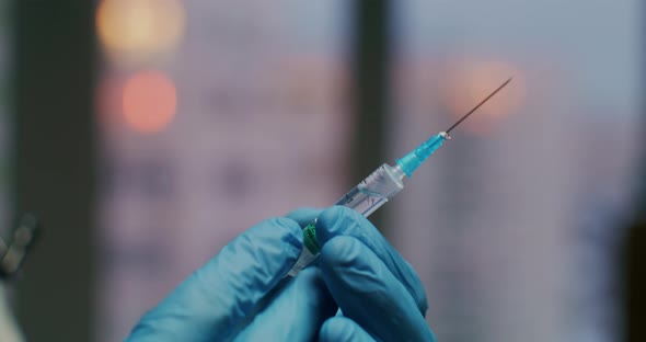 The Doctor Holds a Syringe with a Vaccine in His Hands