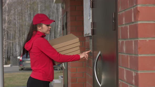 Girl-courier with pizza comes to door