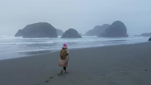 Traveler Woman Walking By Wet Ocean Beach Leaving Footprint on Sand Surface alt