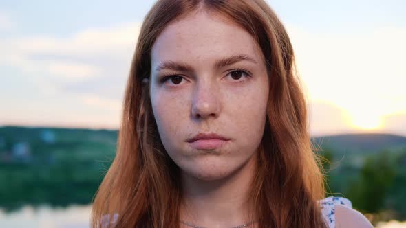Dreamer Face Beautiful Red Haired Young Girl Posing on Background of the Lake alt