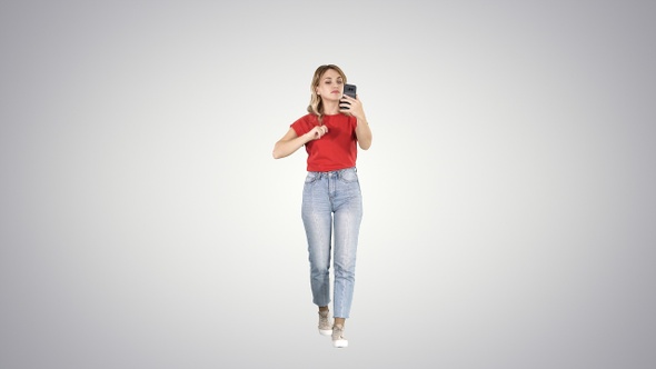 Blonde walking and preening looking in the phone on gradient alt