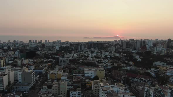 4k aerial bird's eye view over the skyscrapers of the Lima metropolis in Peru at twilight. The city alt