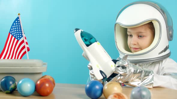 Portrait of a Child Playing at Home in an Astronaut Little Girl 89 Years Old in an Astronaut Costume alt