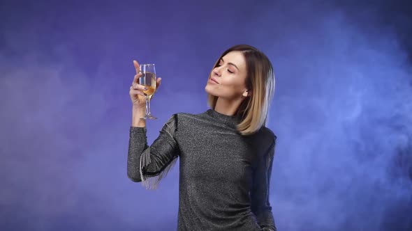 Woman in Silver Shirt Holding Glass of Champagne and Dancing