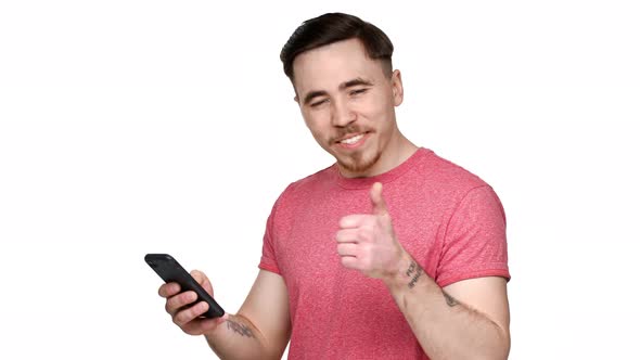 Portrait of European Man Having Beard and Mustache Expressing Surprise While Using Smartphone and alt