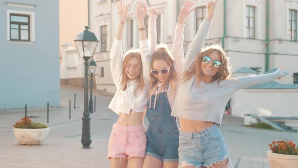Three young female hipster friends posing outdoors alt
