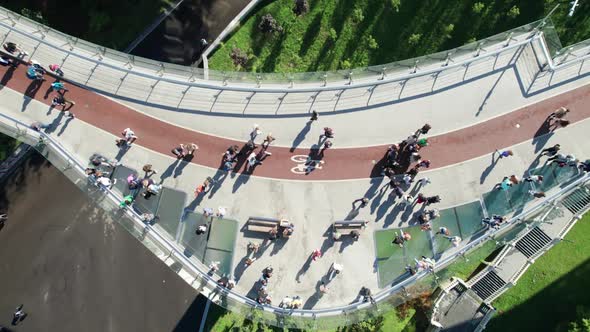 Aerial Top View of Pedestrian Glass Bridge with a Crowd of Walking People alt