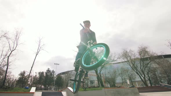 BMX Rider Doing Tricks in Cocncrete Skatepark alt