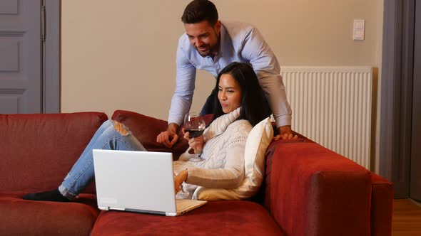 A young couple using a laptop together in the living room