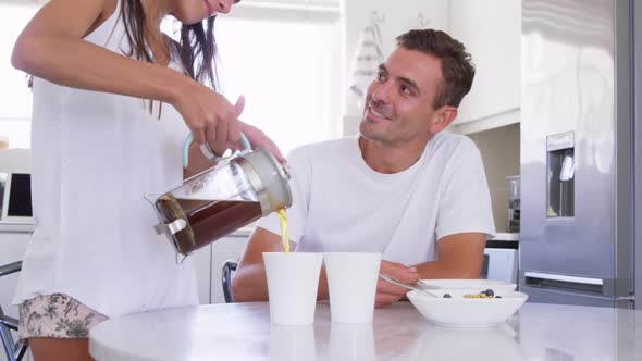 Young woman serving coffee to man on dining table at home 4k