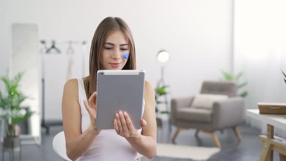 Portrait of Young Attractive Woman with Blue Painted Social Media Icon on Her Face alt