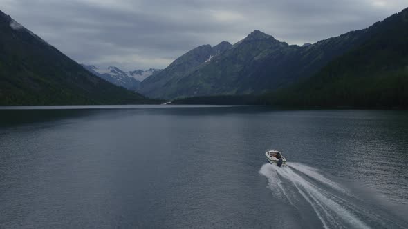 Motorboat on Multin lakes in the middle of mountains under dramatic sky in Altai