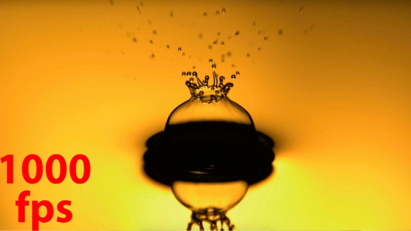 Oil Drop Falling In Slow Motion With Yellow Backlit Background alt