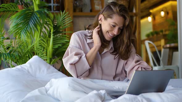 35 Years Old Woman in Front of a Laptop Monitor in Bed alt