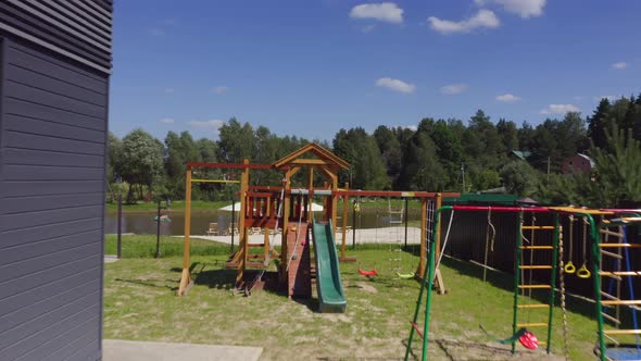 People Taking Rest at the Beach Area with Sand and Loungers Near a Small Lake in a Cottage Village alt