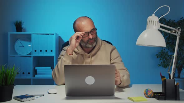 A Business Man Who Is a Company Employee Using a Laptop To Work in an Office Feel Tired From Work alt