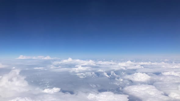 Stunning footage of aerial view above clouds from airplane window with blue sky. view from the airpl