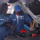 Mechanic man and woman in uniform checking diagnostic for fix and repair car together at garage. - VideoHive Item for Sale