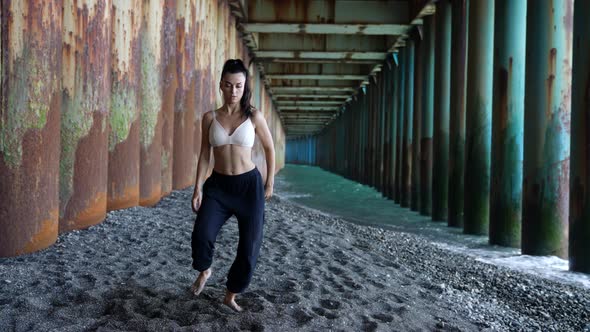 Sexy Lady is Dancing on Shore of Sea Under Pier Moving Sexually Dance Performance alt