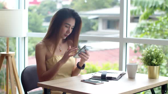 Young beautiful woman using smartphone at coffee shop alt