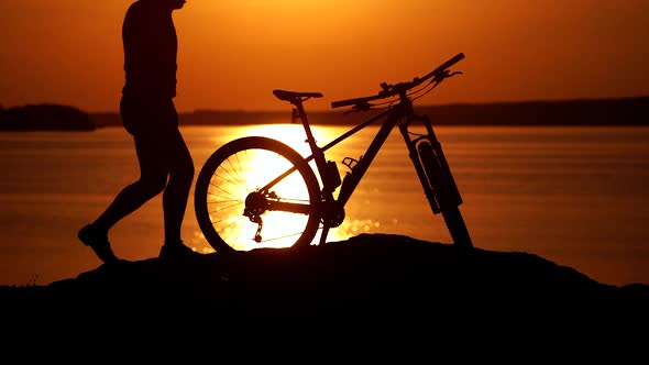 Man with bike outdoor. Athletic male tourist going downhill with mountain bike alt