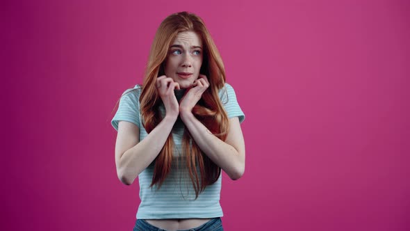 The Scared Redhead Covers Her Face with Her Hands and Then Leans Back Scared with Her Hands in Front alt