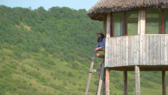 Man relaxing at a wooden pavilion alt