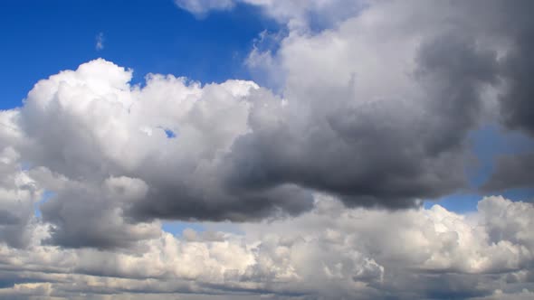 Large, dark cumulus clouds move across the sky